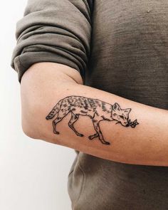 a person with a tattoo on their arm that has a wolf design on the arm