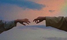 two hands reaching out towards each other with a rainbow in the background