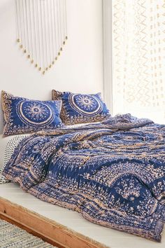 a bed with blue and white bedspread on it