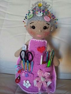 a crocheted doll with lots of crafting supplies on it's back