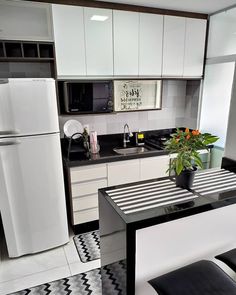 a kitchen with black and white checkered flooring, refrigerator and stove top oven