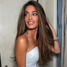 a woman with long brown hair wearing a white dress