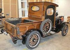 an old fashioned wooden car parked in a garage