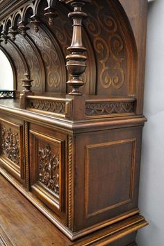 an old wooden bench with ornate carvings on the front and back sides, along with a mirror