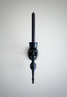 a black candle is hanging on the wall