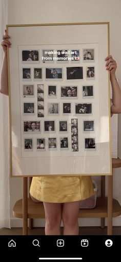 a woman holding up a large framed photo