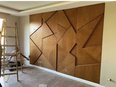 an unfinished room with wood paneling on the wall and ladders in front of it