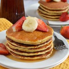 a stack of pancakes topped with bananas and strawberries