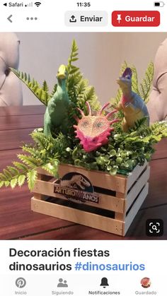 a wooden box filled with fake plants on top of a table