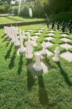 a giant chess set sitting on top of a lush green field