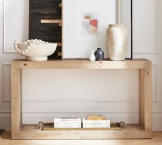 a wooden table topped with vases and books