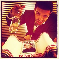 a man in a suit holding a bottle with a photo on it