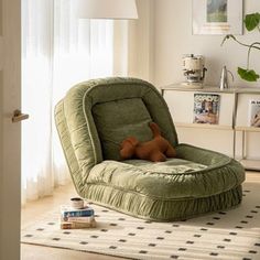 a green chair with a stuffed animal on it's back in a living room