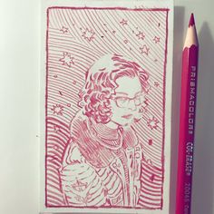 a pink colored pencil next to a drawing of a man with glasses and curly hair