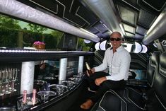 a man sitting in the driver's seat of a limo filled with wine glasses