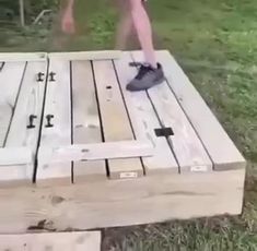 a person sanding on top of a wooden pallet