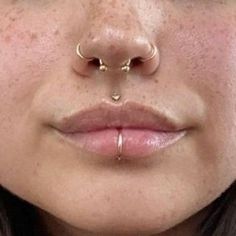 a woman's nose with two piercings on her nose and one in the middle