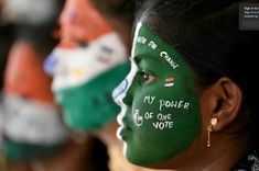 three women with painted faces and words on their face are lined up in the same row