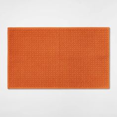 an orange place mat on a white surface