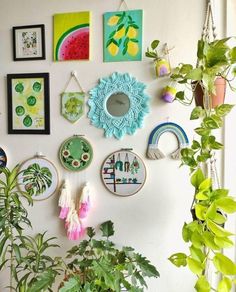 there are many pictures on the wall with plants in front of them and one has a potted plant next to it