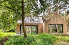 a small wooden house surrounded by trees in the middle of a forest with lots of green grass