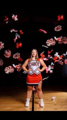 a woman standing on top of a wooden floor next to paper cranes in the air