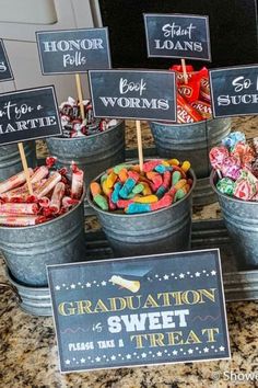 buckets filled with candy and graduation signs on top of a granite counter next to a sign that says congratulations sweet treat