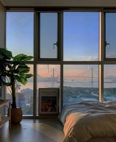 a bedroom with large windows and a view of the city from it's bed