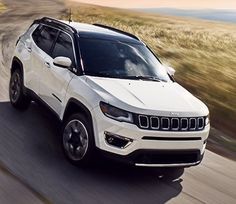 a white jeep driving down a rural road