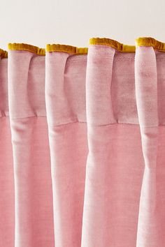 the pink curtains are lined up with yellow trim