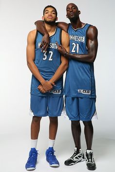 two basketball players standing next to each other with their arms around one another's shoulders