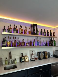 a kitchen counter topped with lots of liquor bottles