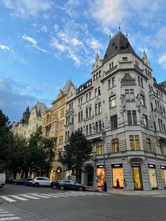 an old building with many windows and cars parked on the street