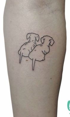 a small tattoo on the leg of a person with a dog sitting on top of it