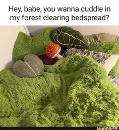 a bed covered in green fluffy blankets and pillows