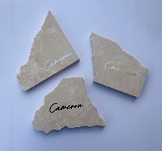 three pieces of stone with the names of four different countries on them, and one is engraved in cursive writing