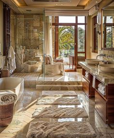 a large bathroom with two sinks and a bathtub in front of a window that looks out onto the outdoors