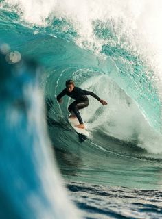 a man riding a wave on top of a surfboard