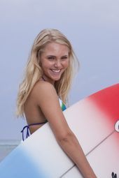 a woman holding a surfboard on the beach