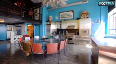 a large dining room with blue walls and wooden floors