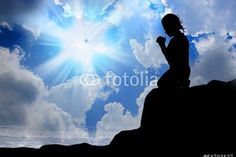 a woman sitting on top of a rock next to the ocean under a blue sky