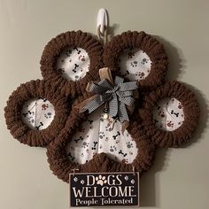 a dog's welcome sign is hanging on the wall with paw prints and bows