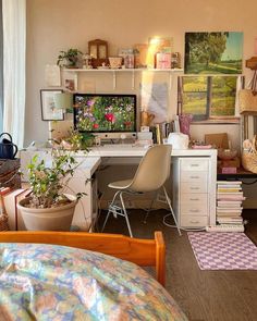 a bedroom with a bed, desk and computer monitor