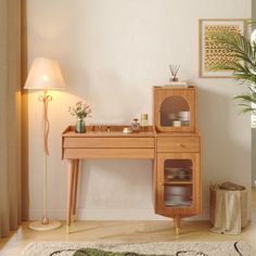 a wooden desk sitting next to a lamp on top of a rug in a living room