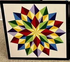 a multicolored geometric design is displayed on a white background with black frame and bottom panel