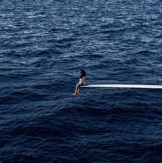 a person sitting on top of a boat in the ocean