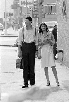 a man and woman are walking down the street