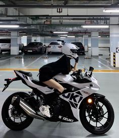 a person sitting on a motorcycle in a parking garage