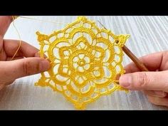 two hands crocheting a yellow doily