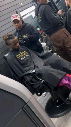 a group of people standing around a barber chair